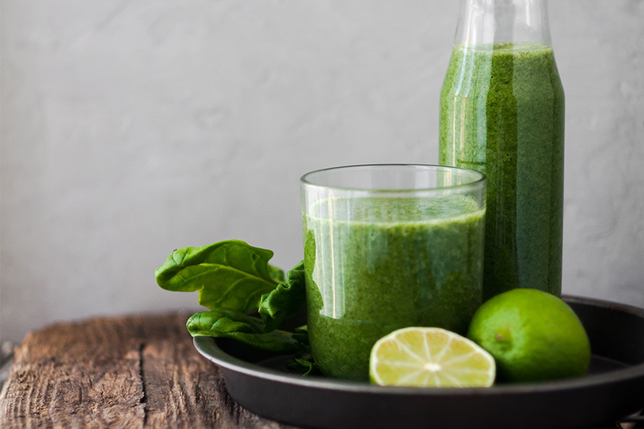 Glasflasche und Glas mit einem grünen Aloe Vera Smoothie