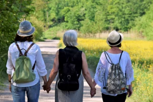 Eine Mutter und ihre beiden Töchter halten sich inmitten der Natur an den Händen