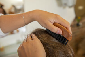 Das Haar einer Friseurkundin wird im NATURsalon sanft gebürstet