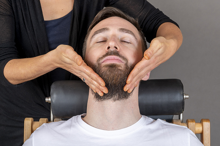 Eine NATURfriseurin streicht über den Bart eines Kunden