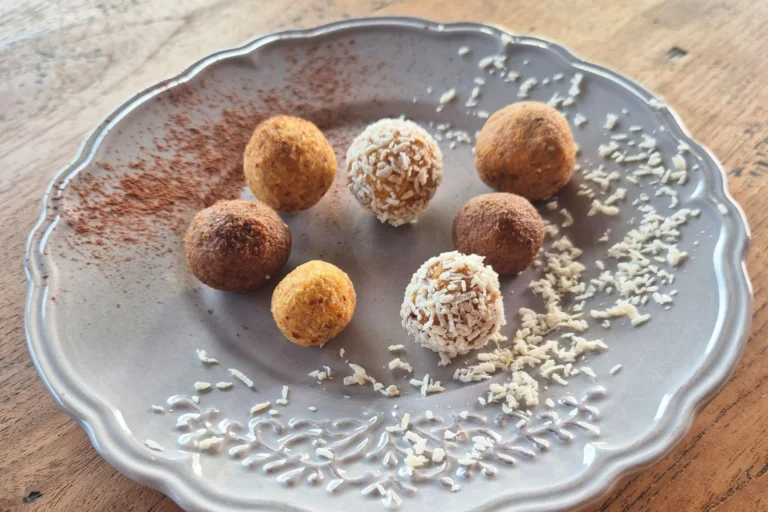 Gesunde Kraft-Kugeln für Kinder mit Karotte, Mandel und Datteln, in Kokosraspeln und Kakaopulver gewälzt.